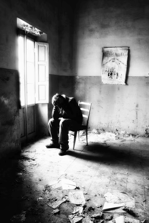 A guy suffering from anxiety sitting alone in a dark room