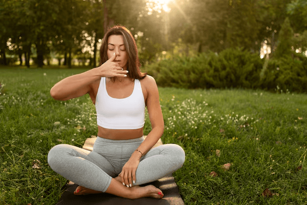 A woman doing yoga and practicing mindful breathing to manage anxiety