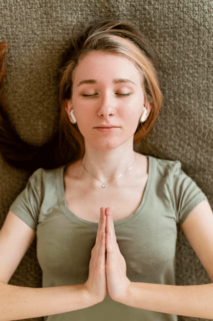 A woman following her bedtime routine of practicing mindful breathing