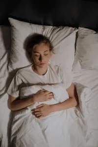 Women lying on bed, figuring how to get more deep sleep